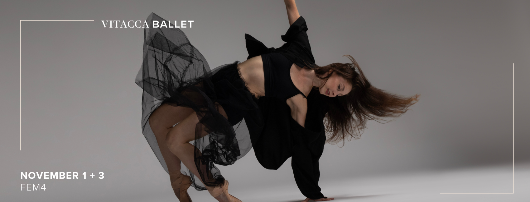 A dancer in a black skirt poses on her tip toes with arms outstretched